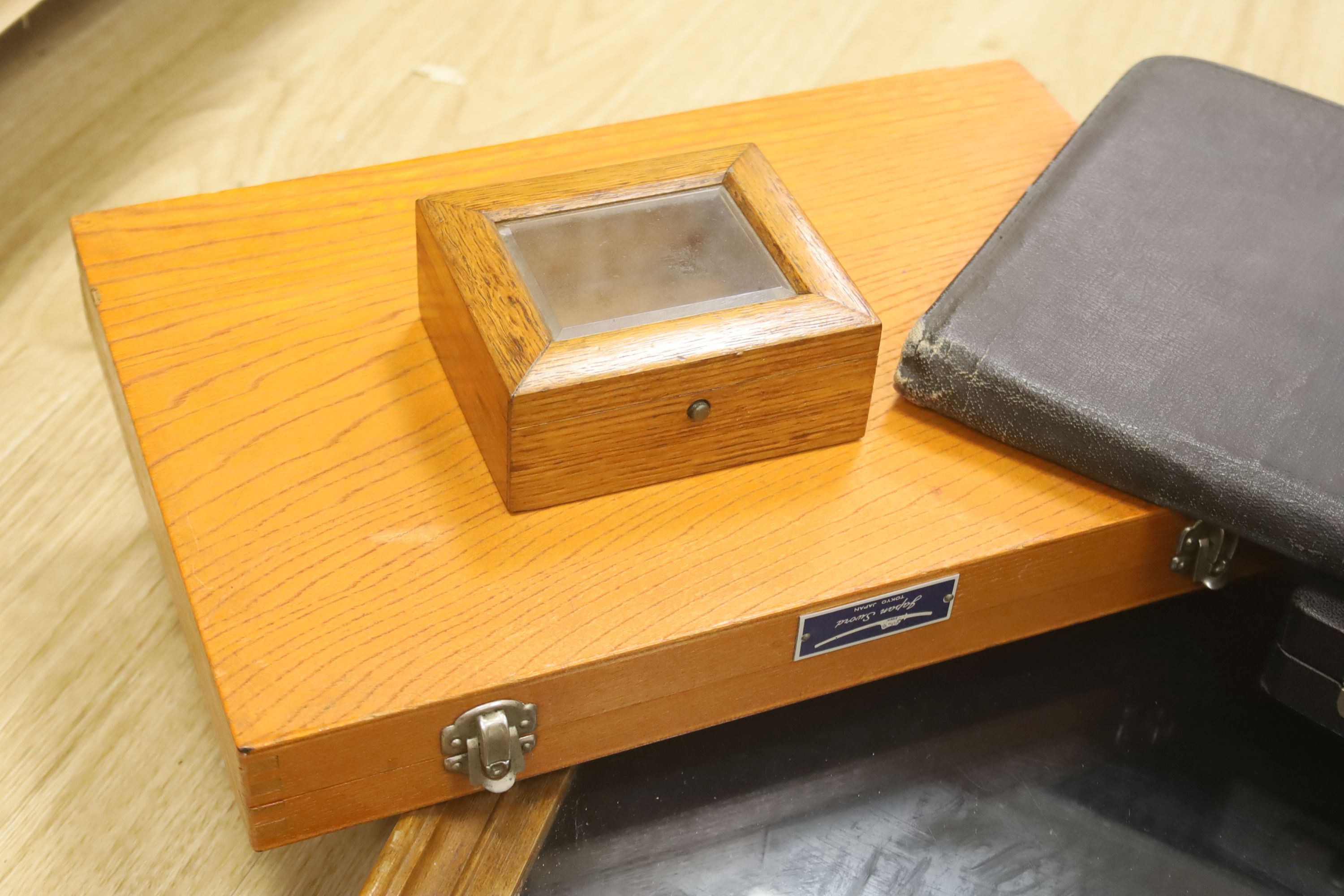 A glass table top cabinet and a collection of pen boxes